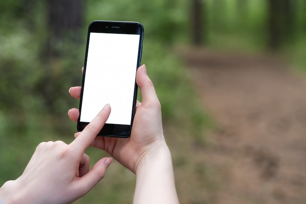 Vrouw houdt telefoon met wit scherm in het park