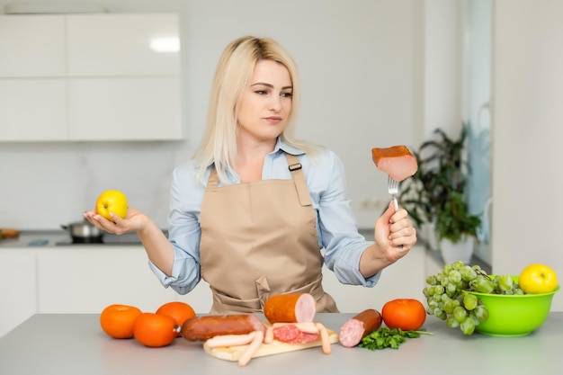 vrouw houdt vast en kiest tussen vlees en appel