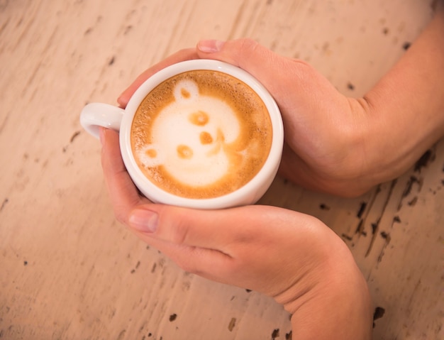 Vrouw houdt warme kop koffie, met foto.