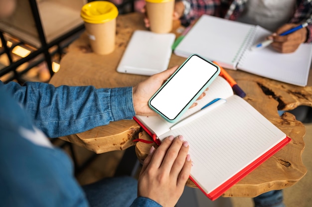 Foto vrouw huiswerk met haar vriend met behulp van smartphone