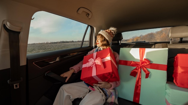 Vrouw in auto met kerstcadeautjes