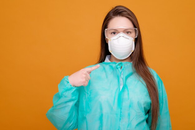 Vrouw in beschermende uitrusting in medisch masker op gele pandemie coronavirus