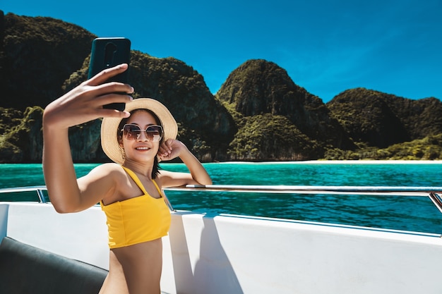 Vrouw in bikini met behulp van een smartphone