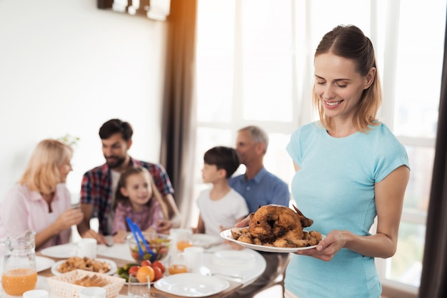 Vrouw in blauw T-shirt staat op achtergrond met chiken.