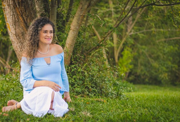 Vrouw in blauwe kleren zittend op het gras