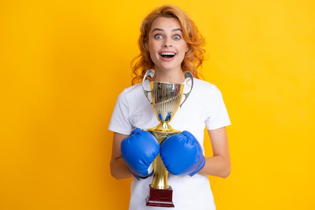 Foto vrouw in bokshandschoenen houdt kampioen winnaar beker portret van succesvolle winnaar vrouw in bokshandschoenen