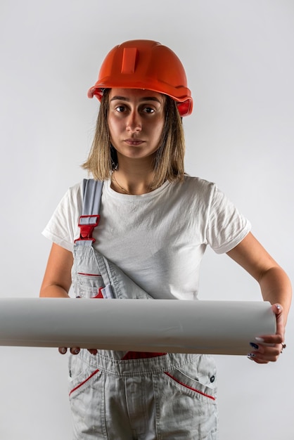 Vrouw in bouw uniforme helm op haar hoofd poseren geïsoleerd op een witte achtergrond