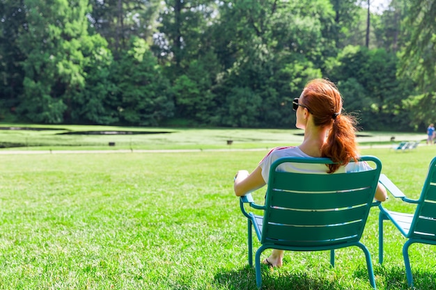 Vrouw in bril ontspannen op greenfield.