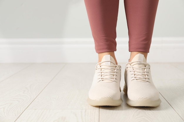 Vrouw in comfortabele stijlvolle sportschoenen binnenshuis close-up Ruimte voor tekst