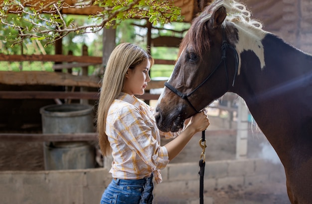 Vrouw in cowgirl-stijl kostuum in een paardenranch met een westerse boerderijomgeving.