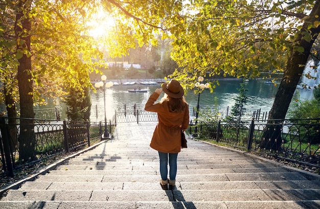 Vrouw in de buurt van het meer in het herfstpark