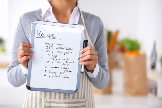 Foto vrouw in de keuken thuis staande in de buurt van bureau met map