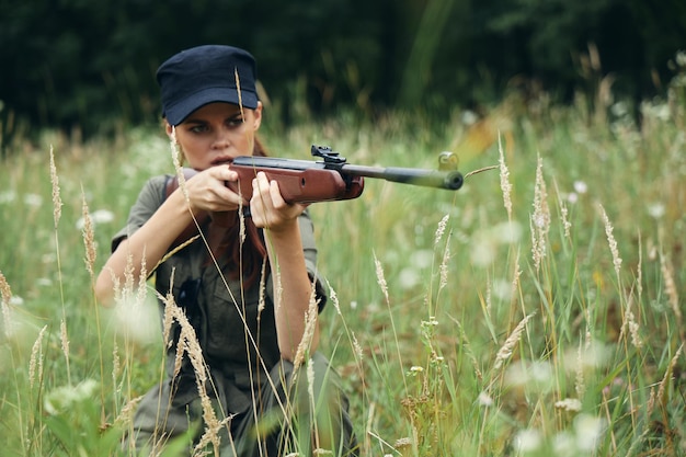 Vrouw in de natuur Een schuilplaats met een wapen kijkt in de scope groene bladeren close-up