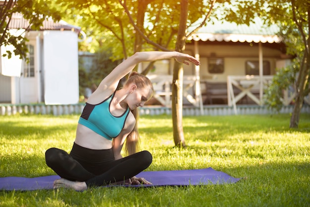 Vrouw in de tuin beoefent yoga. Zomerochtend.