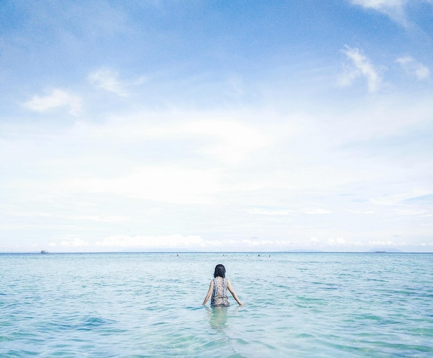 Vrouw in de zee tegen de lucht