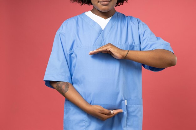 Foto vrouw in dokterskleren op roze achtergrond
