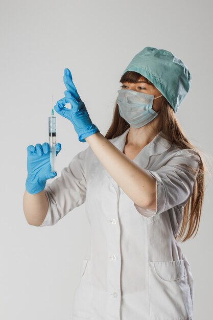 Vrouw in een blauw chirurgisch pak in medische handschoenen