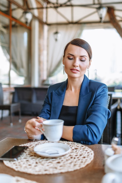 Vrouw in een blauw pak in een koffieplaats