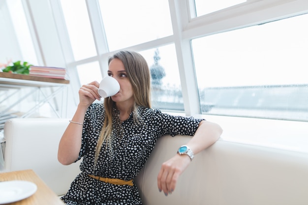 Vrouw in een casual jurk in een coffeeshop