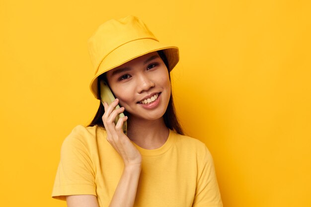 Vrouw in een gele hoed en t-shirt praten aan de telefoon zwart-wit shot