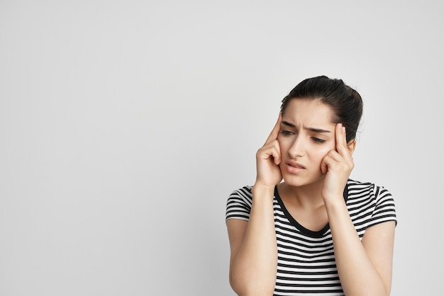 Vrouw in een gestreepte T-shirt pijn in de nek gezondheidsproblemen foto van hoge kwaliteit