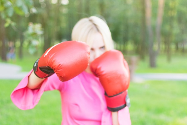 Vrouw in een jurk die bokshandschoenen draagt