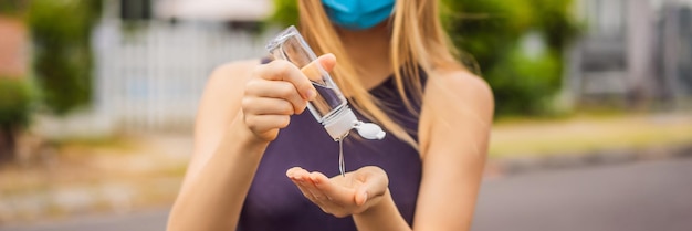 Vrouw in een kleine stad met een medisch masker gebruikt een ontsmettingsmiddel vanwege een coronovirus-epidemiebanner