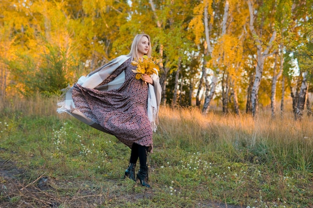 Vrouw in een lange jas in de herfstbos