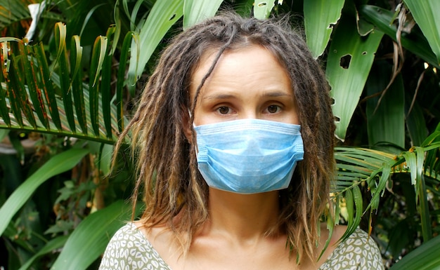 Vrouw in een medisch masker in de natuur