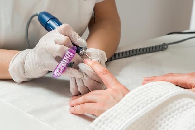 Vrouw in een nagelsalon een manicure ontvangen door een schoonheidsspecialiste met nagelvijl schoonheid en handverzorging