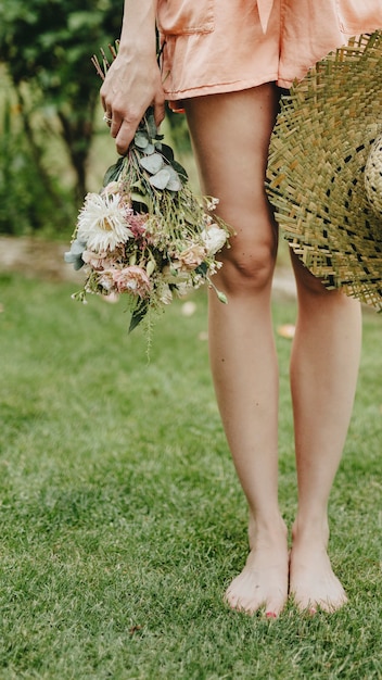 Vrouw in een oranje jumpsuit met een boeket bloemen