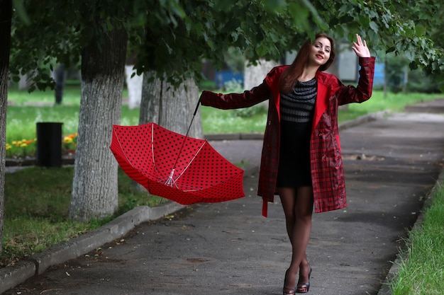 Vrouw in een regenjas en een paraplu