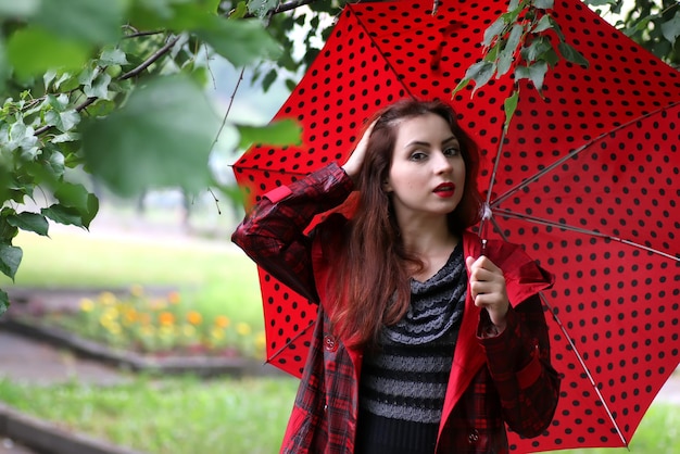 Vrouw in een regenjas en een paraplu