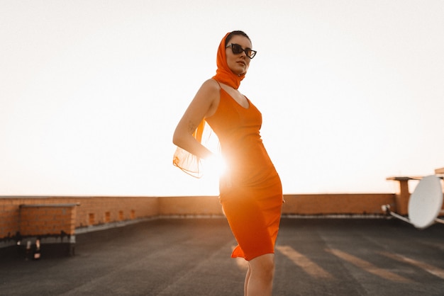 vrouw in een rode jurk bij zonsondergang