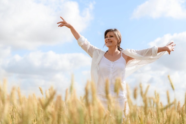 Vrouw in een tarweveld tegen een blauwe lucht met wolken Joodse feestdag Sjavoeot