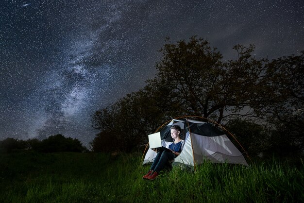 Vrouw in een tent met haar laptop