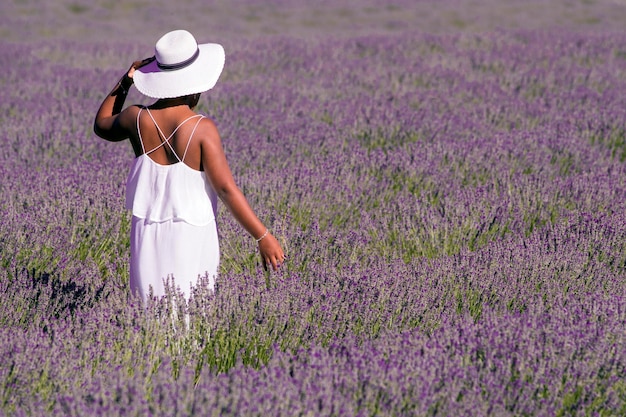 Vrouw in een veld met lavendelbloemen in witte jurk, Spanje