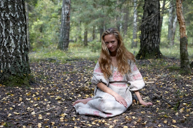 Foto vrouw in een volksjurk in het bos