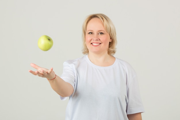 Vrouw in een wit t-shirt met een groene appel