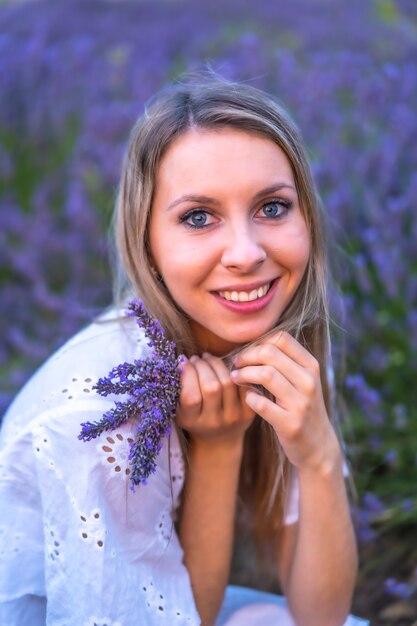 Foto vrouw in een witte jurk in een lavendelveld