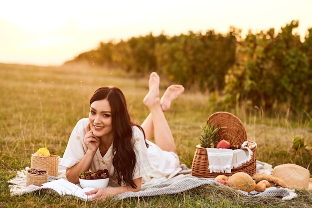 Vrouw in een witte jurk met een picknick