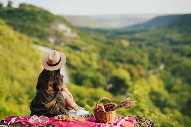 vrouw in elegante jurk en hoed met picknick