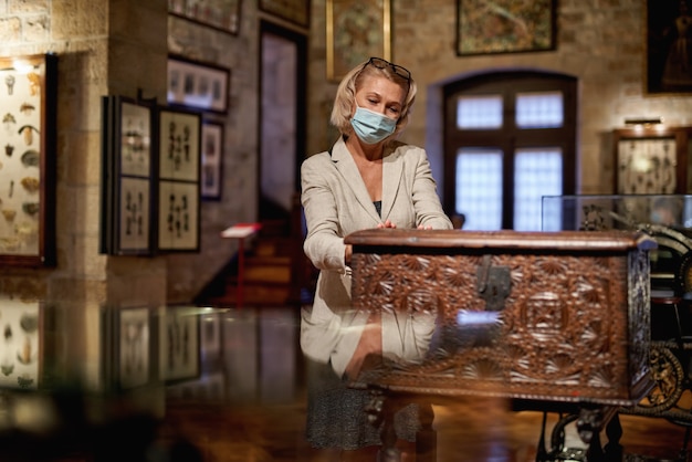 Foto vrouw in galerijkamer op zoek naar antiek