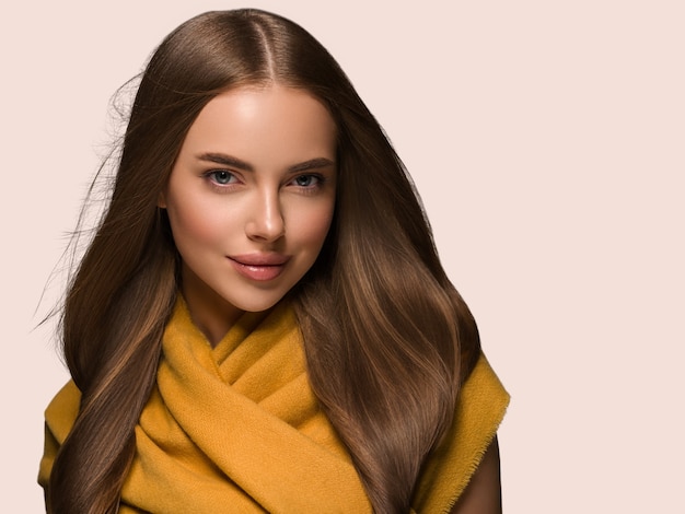 Vrouw in gebreide kleding geel herfst winter stijl lang haar. Kleur achtergrond geel