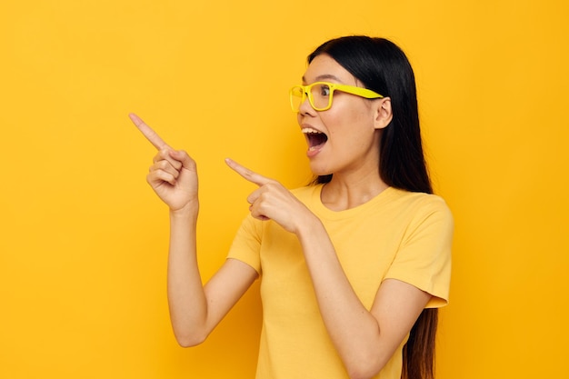 Vrouw in gele t-shirts met bril poseren mode gele achtergrond ongewijzigd
