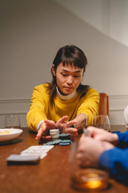 Vrouw in gele trui duwt haar pokerchips