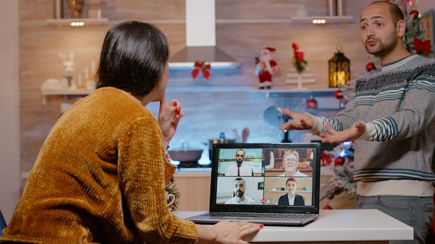 Foto vrouw in gesprek met mensen uit het bedrijfsleven op video-oproepconferentie