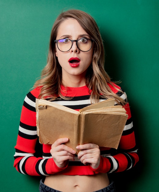 Vrouw in gestreepte sweater en glazen met boek