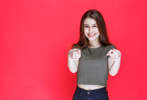 Vrouw in groen shirt wijzend naar de persoon die voor je ligt.