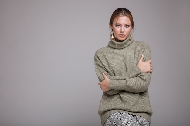 Vrouw in groene trui lange rok patronen op grijze achtergrond Studio opname Monochrome kleuren